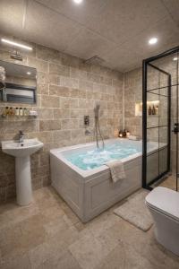 a bathroom with a tub and a sink at Whitestone Hotel in Nevşehir