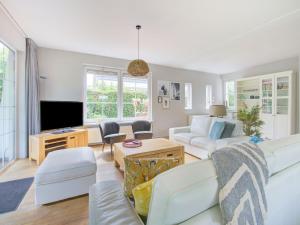 a living room with white furniture and a flat screen tv at Scandinavisch Nr. 221 | 8 Pers. Jacuzzi in Zeewolde