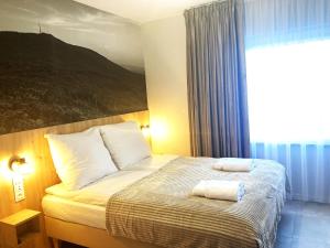 a bedroom with a bed with two towels on it at Apartamenty przy Starym Basenie in Sobótka