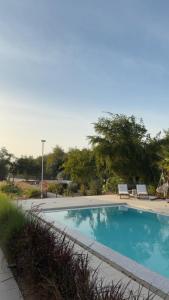a swimming pool with two lounge chairs next to it at Malath Farm in Al Rahba