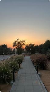 a walking path with a sunset in the background at Malath Farm in Al Rahba