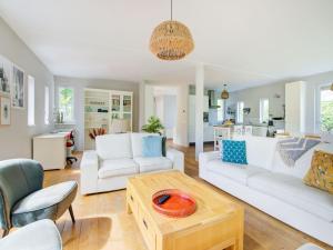 a living room with white couches and a table at Scandinavisch Nr. 221 | 8 Pers. Jacuzzi in Zeewolde