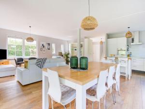 a kitchen and living room with a wooden table and chairs at Scandinavisch Nr. 221 | 8 Pers. Jacuzzi in Zeewolde +27 photos