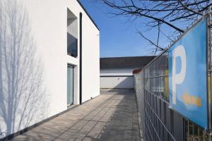 a white building with a fence next to it at JG Hotel & Restaurant Antoniergasse in Memmingen