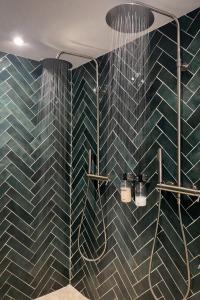 a bathroom with blue tiled walls and a shower at Les Jolies Nuits - À la folie, Loft & Spa in Montrevault