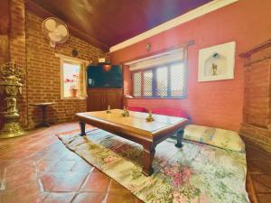 a living room with a table in the middle of a room at Newa Home Bhaktapur in Bhaktapur