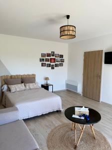 a bedroom with a bed and a coffee table at Chambre d´hôtes La Jonchère in Les Herbiers