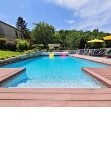 a large swimming pool with blue water in a yard at Domaine du Cardou in Puy-lʼÉvêque