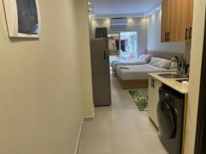 a kitchen with a refrigerator and a living room with a bed at Florenza Resort- Hurghada in Hurghada