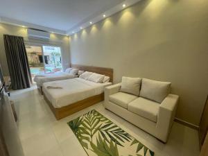 a bedroom with a bed and a chair and a couch at Florenza Resort- Hurghada in Hurghada