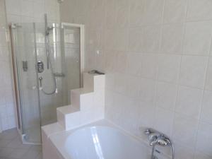 a white bathroom with a shower and a tub at Ferienwohnung Alpenvilla in Bischofswiesen +38 photos
