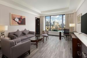 a living room with a couch and a table at Courtyard by Marriott Hangzhou Wulin at West Lake in Hangzhou