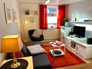 a living room with a couch and a desk with a television at Haegerende _Alte Liebe_ in Groß Kirr
