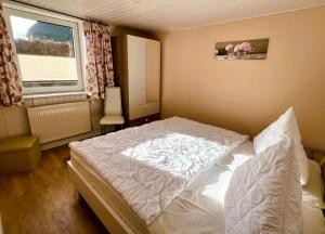 a bedroom with a white bed and a window at Haegerende _Alte Liebe_ in Groß Kirr