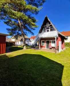 a house with a tree and a slide at Haegerende _Seitensprung_ in Groß Kirr