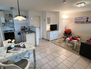 a living room with a table and a kitchen at Haegerende _Seitensprung_ in Groß Kirr