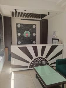 a living room with a table and a painting on the wall at Hotel Mahavir in Ankleshwar +11 photos