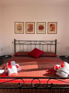 a bedroom with a bed with red sheets and red pillows at Casetta al Belvedere - Lake View in Vercana