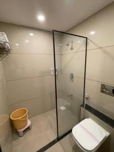 a bathroom with a glass shower with a toilet at Hotel Mahavir in Ankleshwar