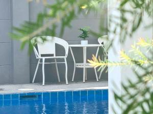 a white table and chairs next to a pool at Bestest Pool Villa in Krabi