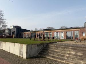 a brick building with windows and grass in front of it at Wohnglück Alte Werft Leer in Leerort