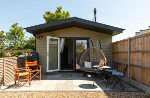 a cottage with a patio with a table and chairs at Pear Tree Cabin in Whitstable