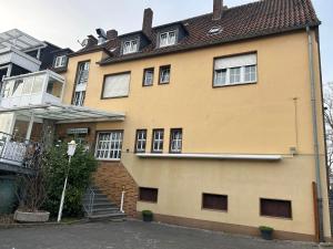 a yellow house with a staircase in front of it at TM Hotel Westfalen in Lünen