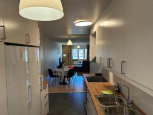 a kitchen with a sink and a table with chairs at Noah Longstay Bygatan in Västerås