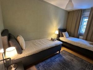 a room with two beds and a couch and a window at Noah Longstay Bygatan in Västerås