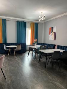 a dining room with tables and chairs and a couch at Aq-Jaiyq Halal Hotel in Karagandy