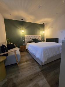 a bedroom with a large white bed and a desk at Studio 3 - Stylish apartment central to hospital and racecourse in Cheltenham