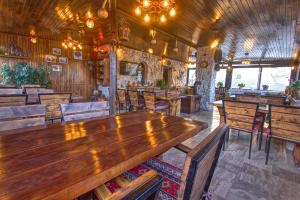 a restaurant with wooden tables and wooden chairs at Babili Cappadocia Cave in Nevşehir