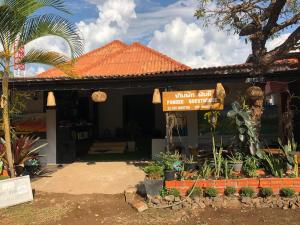 a sign in front of a house with a building at Fundee Guesthouse in Pakse
