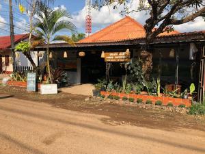 a building with an orange roof next to a street at Fundee Guesthouse in Pakse