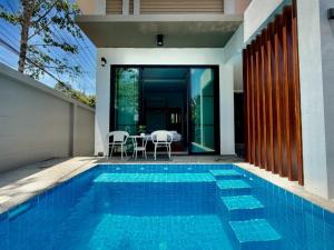 a swimming pool in front of a house at Bestest Pool Villa in Krabi