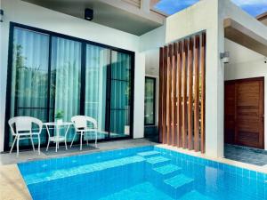 a pool in a house with a table and chairs at Bestest Pool Villa in Krabi