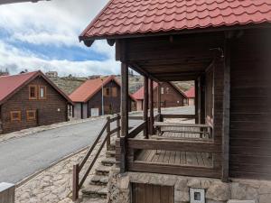 a small wooden building with a red roof on a street at Chalé 24 in Penhas da Saúde