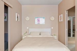 a white bedroom with a large bed in it at French house in Paris