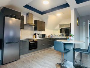 a kitchen with stainless steel appliances and a table at Pier House Luxury Apartment in Dingle