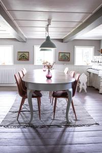 a dining room table with chairs and a vase on it at Hotel Strandgaarden in Vesterø Havn