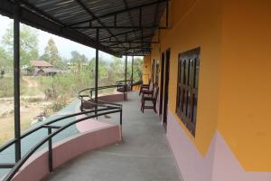 a balcony of a building with chairs and tables at Shanta Ghar A Rustic Guesthouse in Chitwan