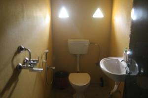 a bathroom with a toilet and a sink at Shanta Ghar A Rustic Guesthouse in Chitwan