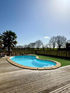 a swimming pool on a wooden deck at Chambre d´hôtes La Jonchère in Les Herbiers