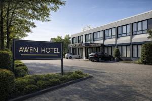 a sign in a parking lot in front of a hotel at Awen Hotel Vechta in Vechta