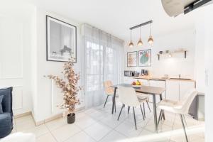 a kitchen and dining room with a table and chairs at L'Écrin Piano, chic near Paris in Asnières-sur-Seine