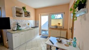 a kitchen with white cabinets and a table and a window at Harmonie im Grünen-Erdgeschoss-Ferienwohnung mit eigenem Eingang und direktem Gartenzugang in Wathlingen