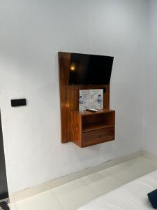 a flat screen tv on a white wall at JS Guest House in Seminyak