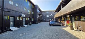 a car parked in a parking lot between two buildings at Grace Villas 8 in East London +13 photos