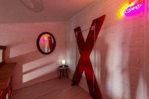 a room with a sign on the wall and a mirror at love escape "Love Room" in Saint-Paul-Trois-Châteaux