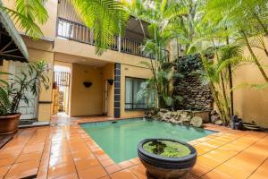 a swimming pool in a courtyard with palm trees at Florida Palms Guesthouse in Durban